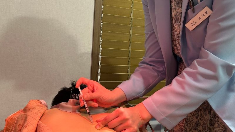 오십견 근막이완추나, 원장이 환자의 어깨 앞쪽 조직을 풀고 있는 장면]]