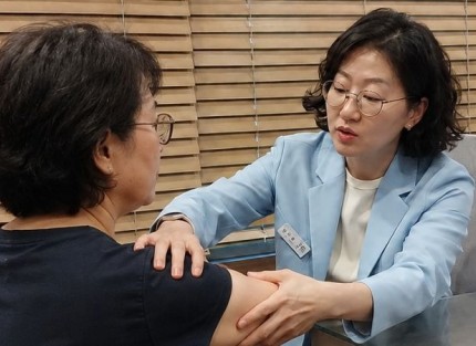 오십견 상담, 원장이 환자의 팔을 들어 어깨 가동범위를 확인하는 장면