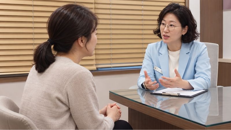 불면증 아침 두통 상담, 원장과 환자가 마주 앉아 이야기하는 진료실