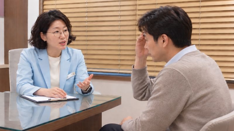 어지럼증 메스꺼움 상담 장면, 원장과 마주 앉아 설명을 듣는 모습