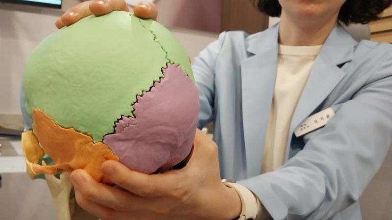 진료실에서 두통 환자와 원장이 마주 앉아 상담하는 모습