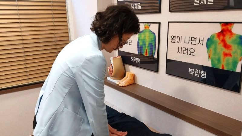 만성 요추 염좌 상담, 허리 양쪽 굳은 정도를 손으로 확인하는 장면
