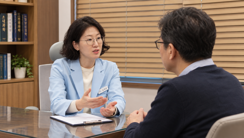 진료실에서 원장이 남성 환자와 야간 식은땀 증상을 상담하는 모습